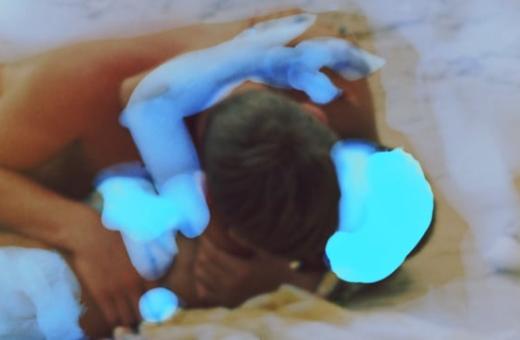 Still from the film of a couple embracing on the beach.