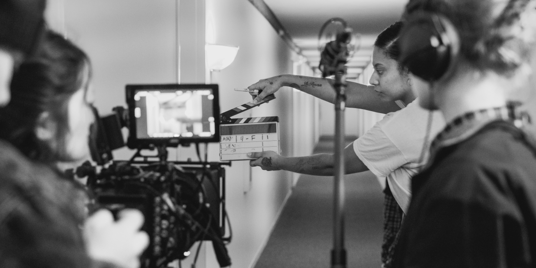 Behind the scenes of a film crew setting up a shot in a hallway.