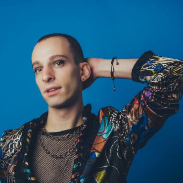 Truth Bachman in a colorful jacket on a blue background