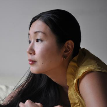 A profile of a woman who is wearing yellow dress