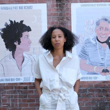 Madeleine Hunt-Ehrlich in front of a brick wall in Bed-Stuy