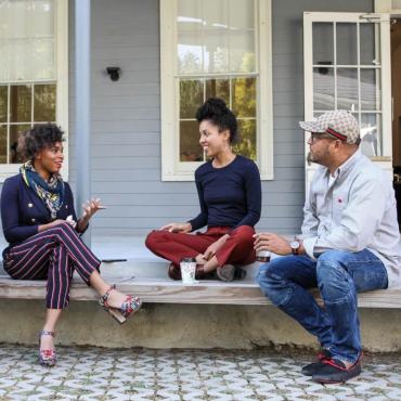 Documentary Lab participants sitting on a porch talking.