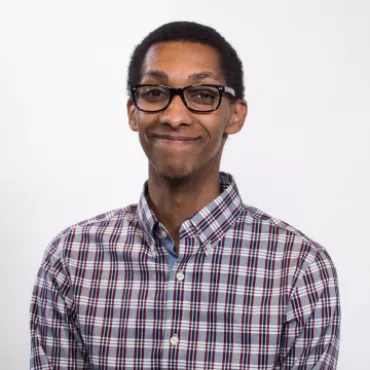 Felix grins at the camera against a white background.