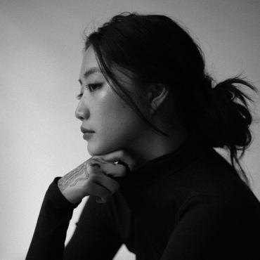 Side profile of thirty-something Asian femme in black and white.