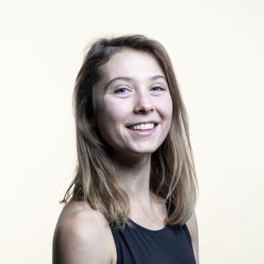 Madeline smiling at the camera against a white backdrop